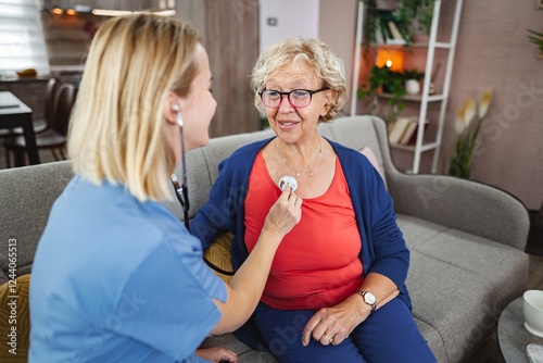 Caring nurse conducts a health check on an elderly woman at home