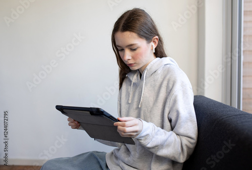Teenage girl on sofa with iPad