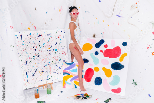 Female artist in her art studio with colorful paintings photo