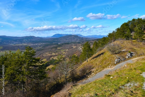 Forest covered landscape in Notranjska, Slovenia with clouds above Nanos plateau in the distance photo