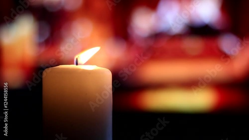 Burning candle on the background of a beautiful fireplace.