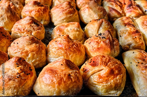 Samsa made from puff pastry on a baking sheet, freshly baked, golden brown, appetizing. Central Asian cuisine photo