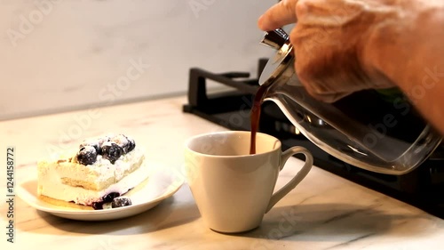 A man pours coffee in the kitchen.