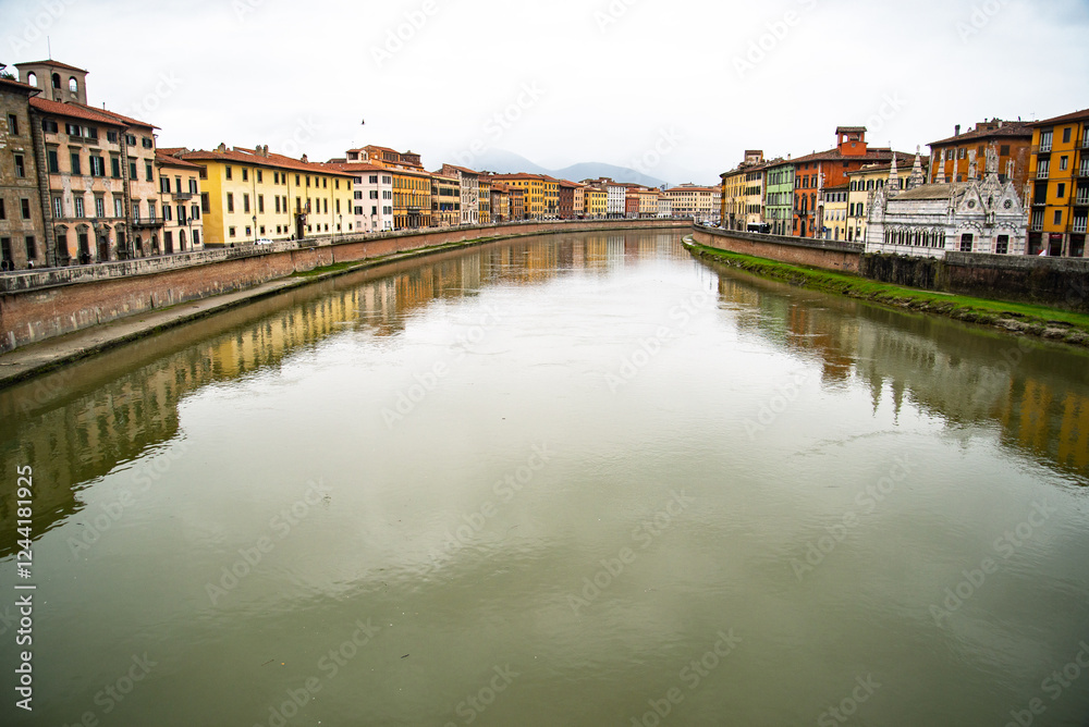 Naklejka premium View on Arno river and colorful building, reflection in water, Pisa, Italy