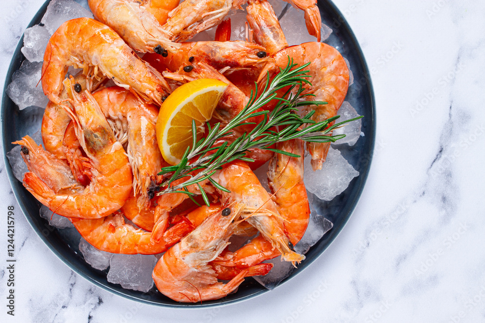 Freshly frozen shrimp on ice, with lemon and rosemary, on the marble table, top view, no people Freshly frozen shrimp on ice, with lemon and rosemary, on the marble table, top view, no people