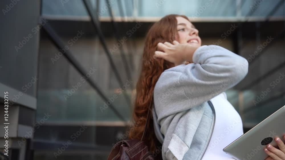 Young woman in an urban setting, using a tablet and headphones, engaging in education Young woman in an urban setting, using a tablet and headphones, engaging in education