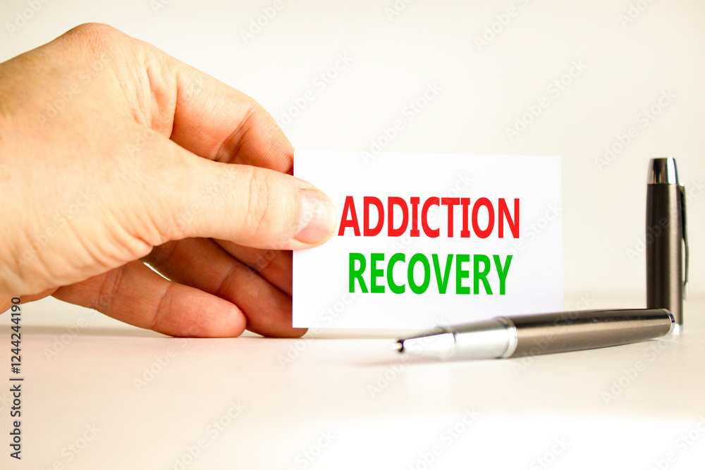 Addiction recovery symbol. Concept words Addiction recovery on beautiful white card. Psychologist hand. Beautiful white paper background. Psychology addiction recovery concept. Copy space. Addiction recovery symbol. Concept words Addiction recovery on beautiful white card. Psychologist hand. Beautiful white paper background. Psychology addiction recovery concept. Copy space.