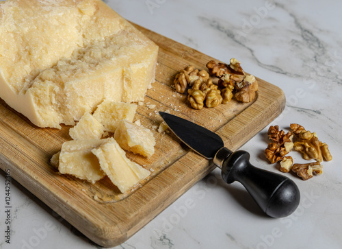 Tagliere in legno con formaggio di grana e noci