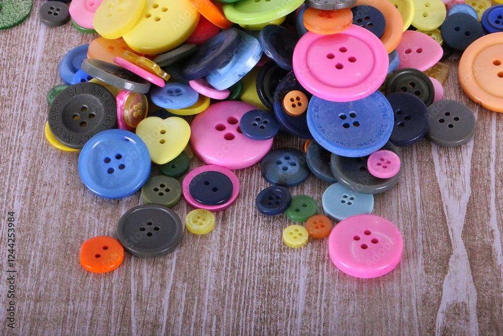 close-up of a pile of colorful buttons lying on a wooden table close-up of a pile of colorful buttons lying on a wooden table