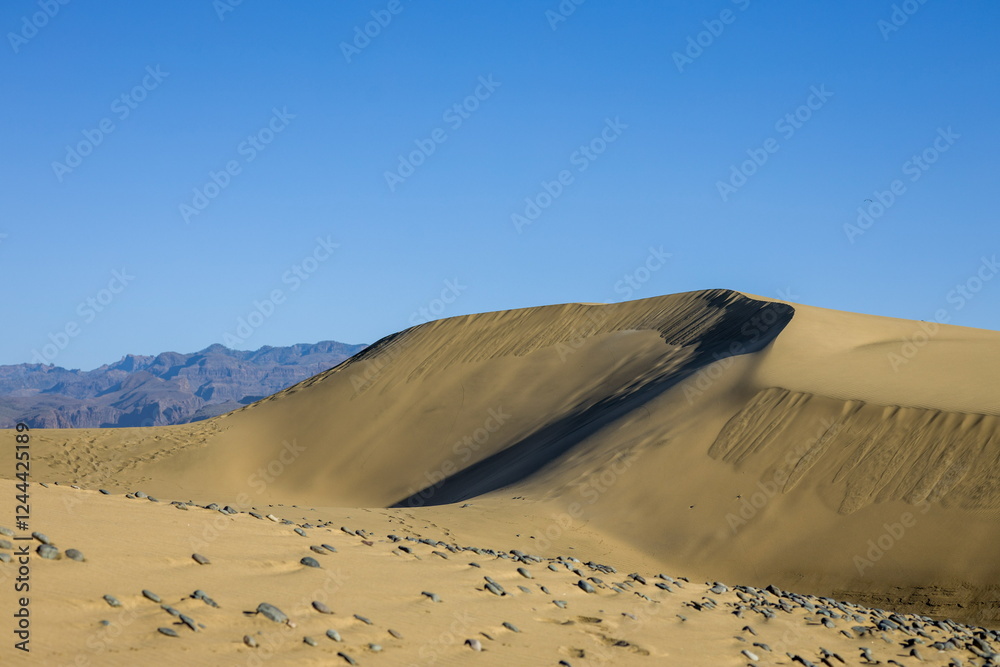 Maspalomas Dunes in Gran Canaria. Textured sand dunes with patterns, shadows, and faint footprints.