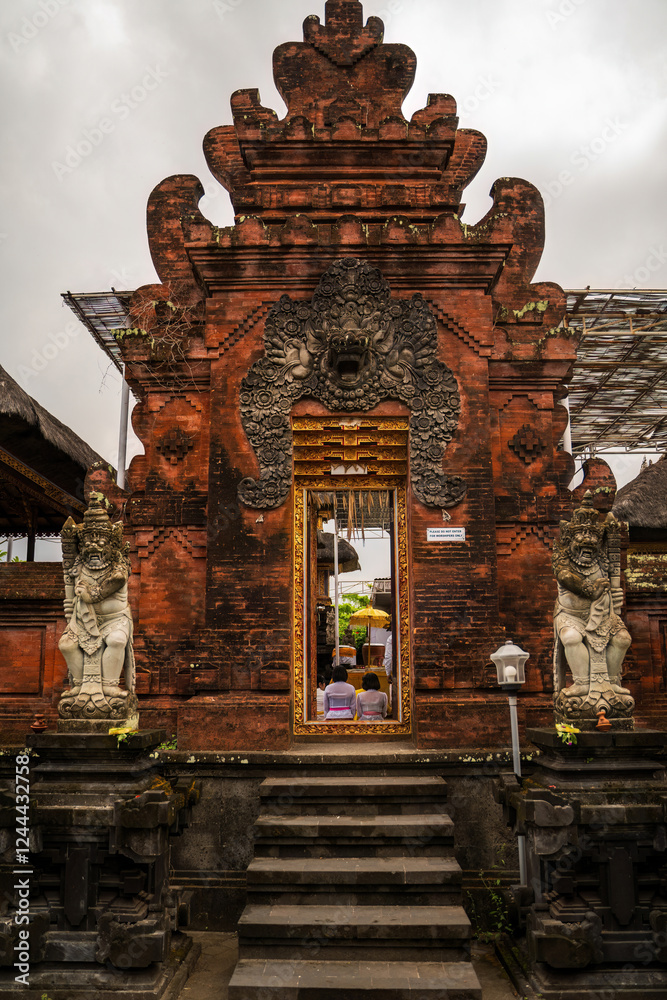 Traditional Balinese Temple with Ornate Carvings and Stone Statues at the Entrance