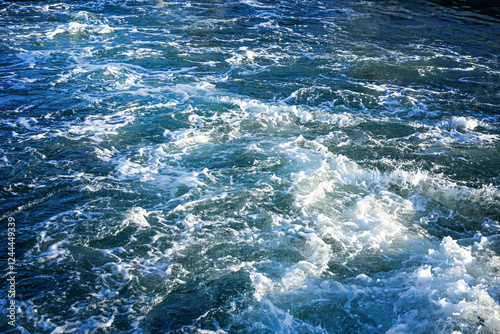 Churned up sea water with white foam behind a ship at full speed, ocean background texture, travel theme, copy space