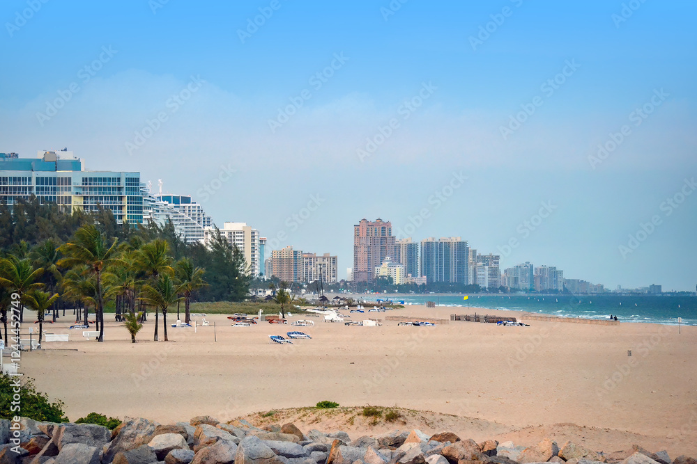 A beach with palm trees and a city in the background A beach with palm trees and a city in the background