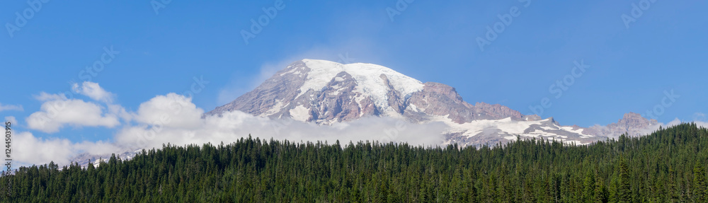Fototapeta premium Washington State, Mount Rainier National Park. Snowcapped Mount Rainer and low clouds, view from Reflection Lakes area