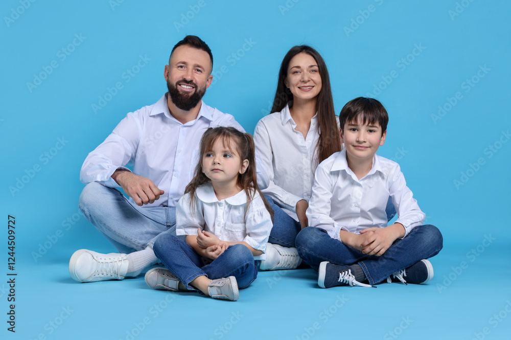 Happy parents and their children on light blue background Happy parents and their children on light blue background