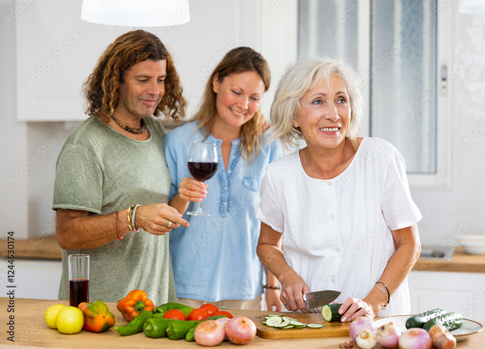 Portrait of smiling mature housewife preparing family dinner at kitchen table Portrait of smiling mature housewife preparing family dinner at kitchen table