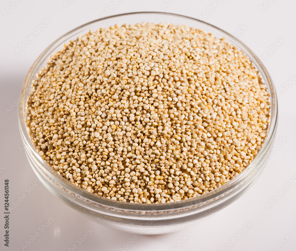 Glass bowl with raw quinoa seeds on white surface. Healthy and nutritious food.. Glass bowl with raw quinoa seeds on white surface. Healthy and nutritious food..