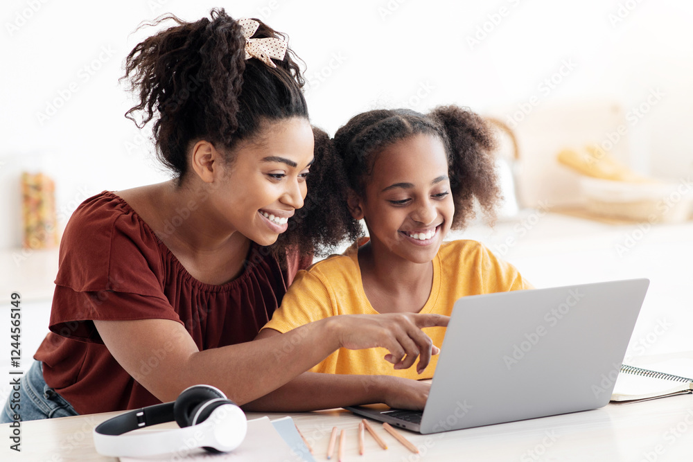 Creative black mother and daughter working on school project, using modern laptop, taking notes, cheerful afro-american woman helping her teen kid with homework, kitchen table, copy space Creative black mother and daughter working on school project, using modern laptop, taking notes, cheerful afro-american woman helping her teen kid with homework, kitchen table, copy space