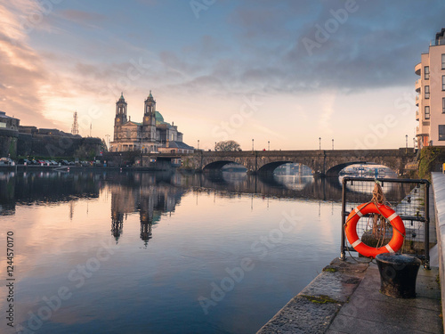 View on Riverside area of Athlone city, Ireland. Old town with long history and educational, shopping and industrial center. Church of Saints Peter and Paul in the background and town bridge photo