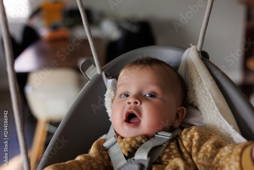 Beautiful Baby on an Indoor Swing with Blue Eyes