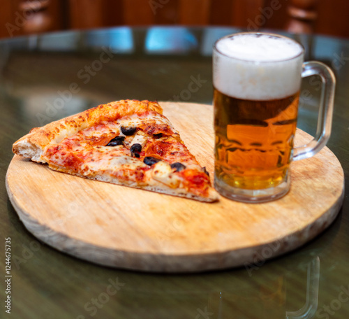 trozo de pizza con cerveza sobre una tabla redonda de madera