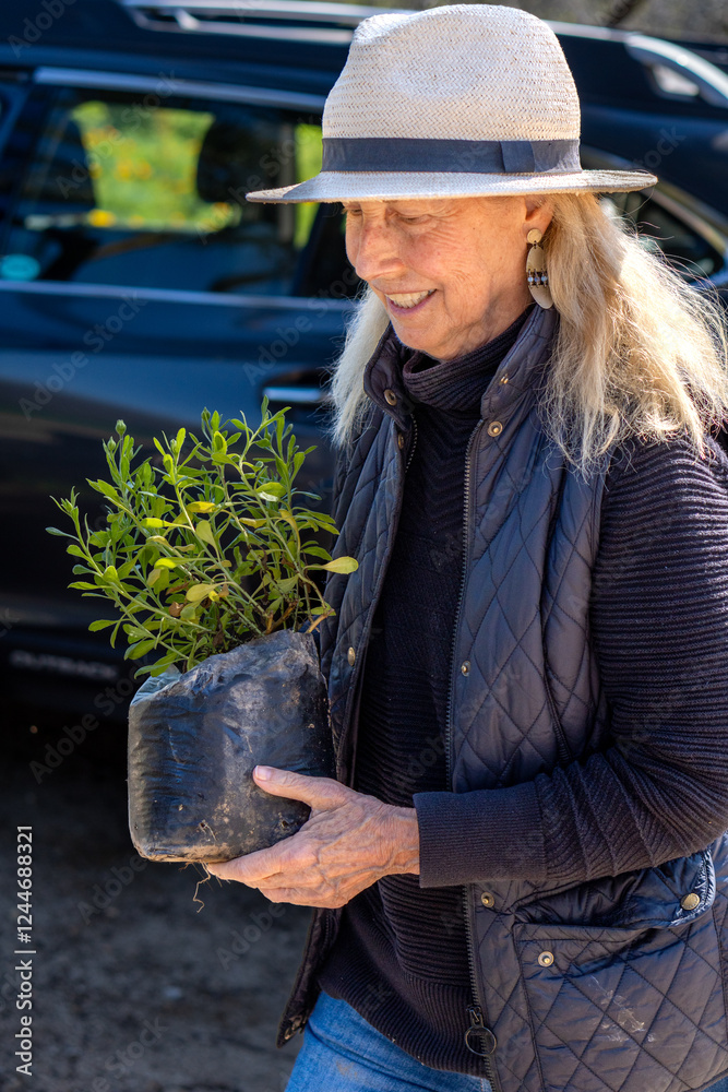 Smiling Woman Carrying Freshly Purchased Plants