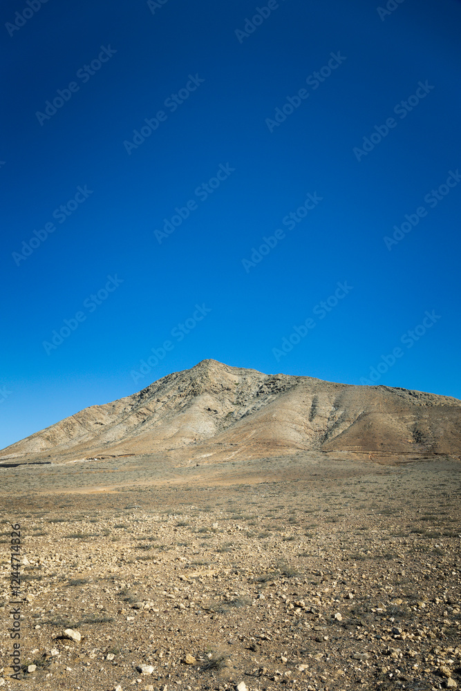Strange, lunar landscape of the Fuerteventura volcanos and dirt roads in the interior of the island. Mountains, sands Strange, lunar landscape of the Fuerteventura volcanos and dirt roads in the interior of the island. Mountains, sands