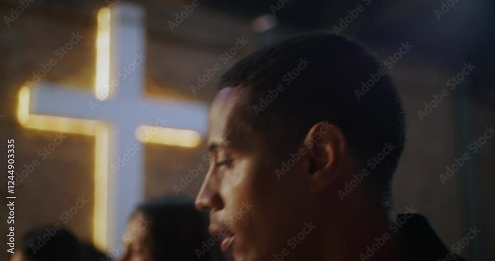 Man rising from his seat in a modern church setting, with a glowing cross on a brick wall in the background, appearing focused and inspired during worship Man rising from his seat in a modern church setting, with a glowing cross on a brick wall in the background, appearing focused and inspired during worship