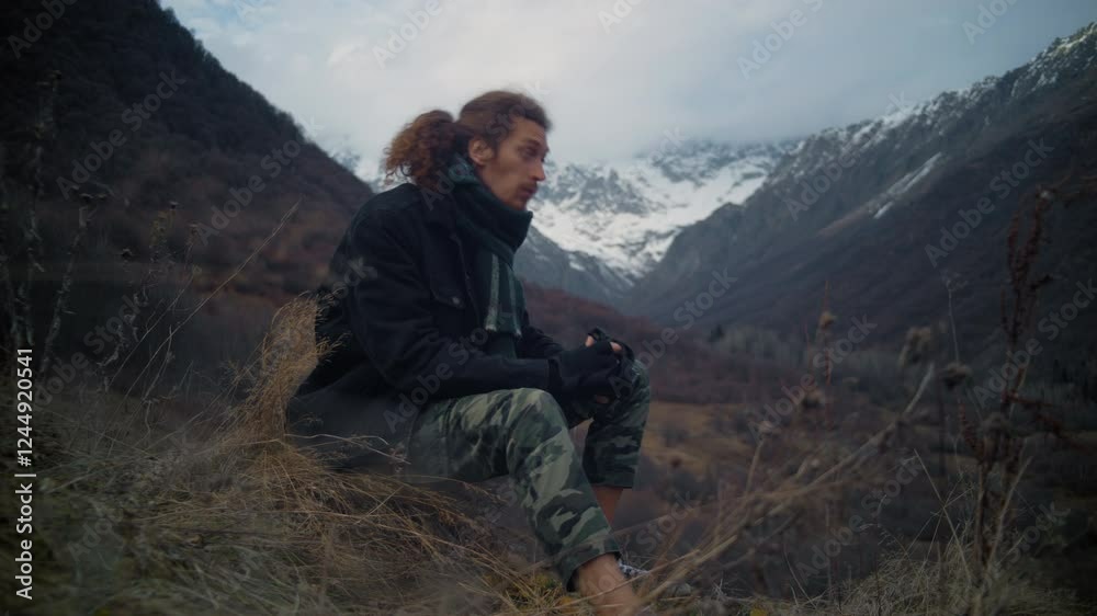 Full Body Shot of Man with Long Hair Loading Film Camera and Taking Picture of Mountains Full Body Shot of Man with Long Hair Loading Film Camera and Taking Picture of Mountains