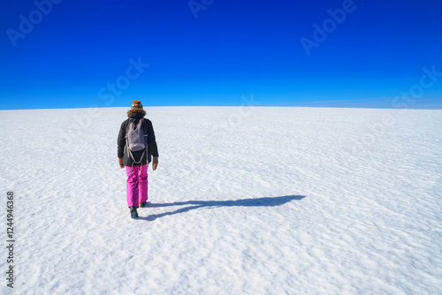 Obraz na płótnie Arctic winter landscape - view of a snowy desert field with a walking man in the rays of the winter sun w salonie