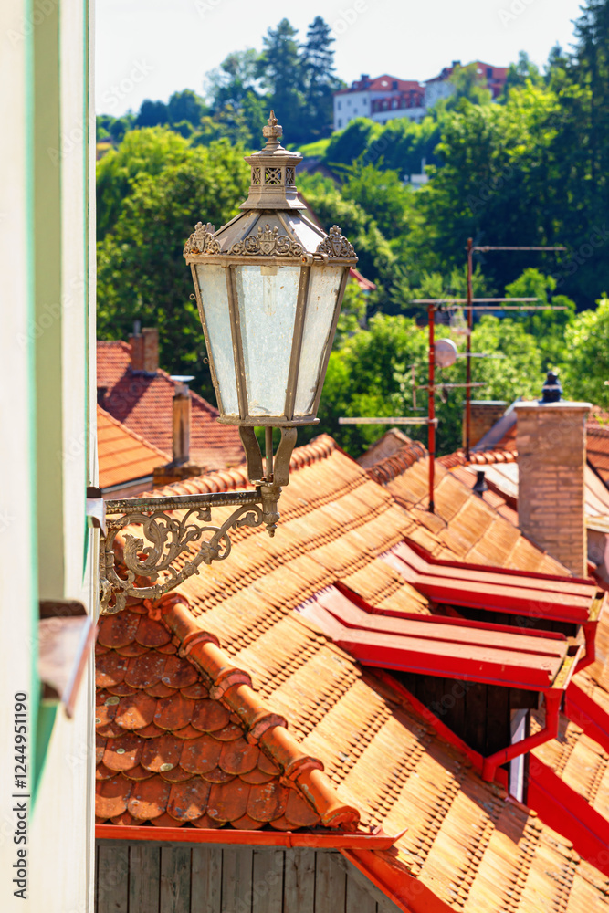 Summer cityscape - close-up view of an antique street lamp in the historical center of Cesky Krumlov, Czech Republic