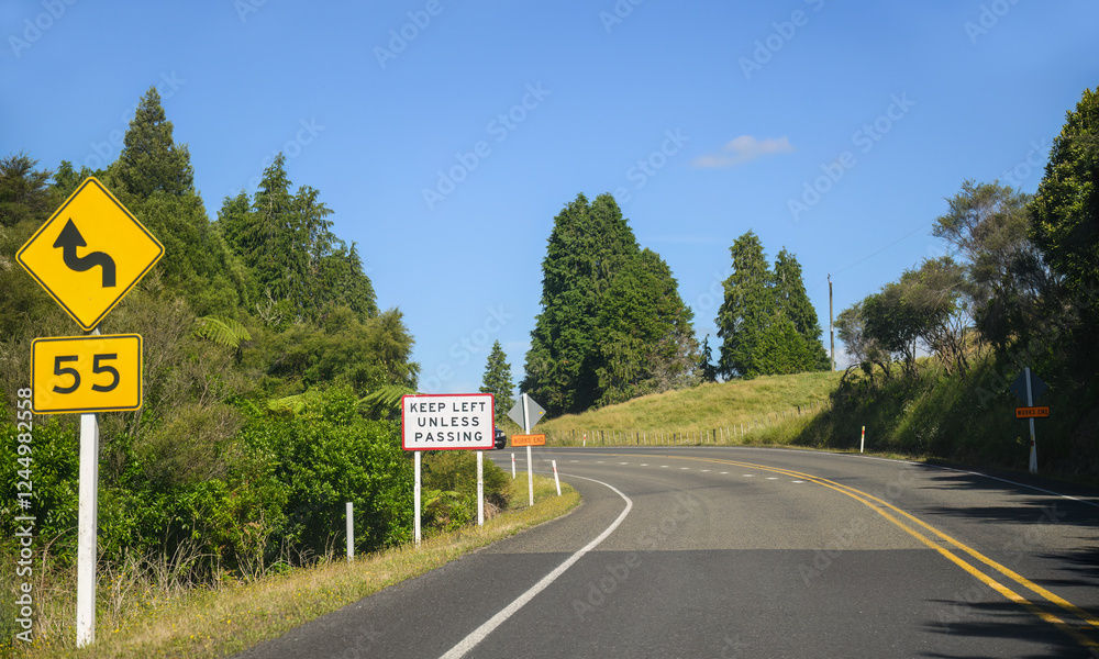 Keep Left Unless Passing road sign on a winding road. North Island. New Zealand.