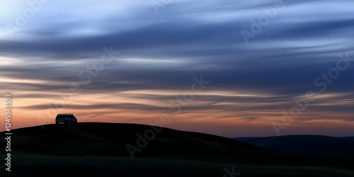 Van sits atop hill at sunse...