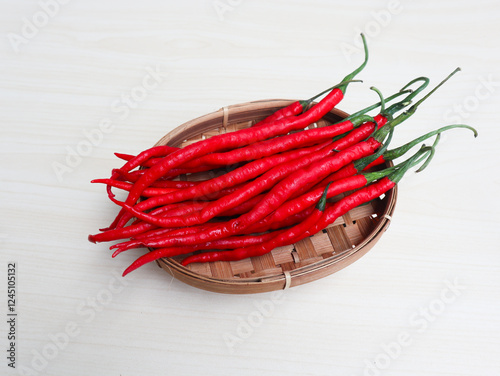 Cabe merah keriting or Curly red chili is most often used in every Indonesian cuisine, giving it a spicy and delicious taste. on a bamboo plate on wooden background photo