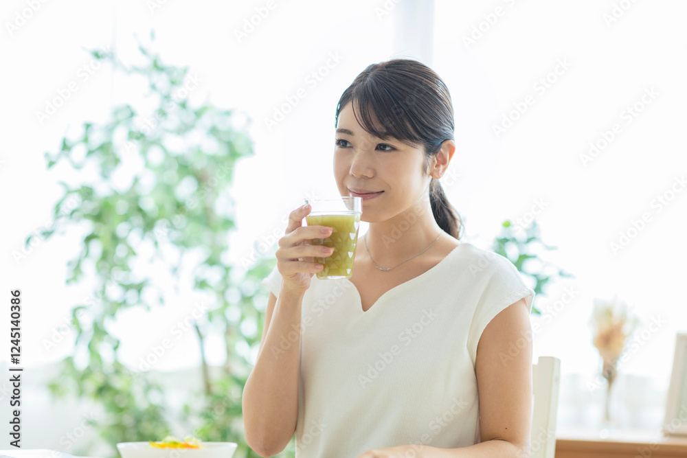 野菜ジュースを飲む女性