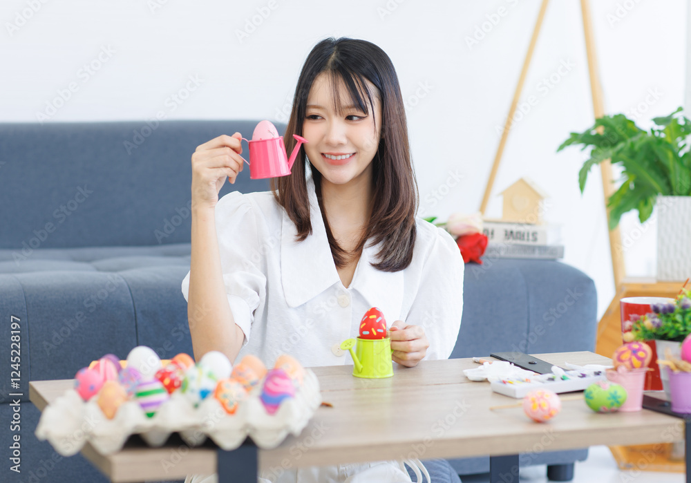 Asian beautiful attractive cheerful young cute lovely sweet woman wearing casual clothes, happy funny smile holding painted colorful eggs decorating sitting at home, preparing for Easter celebration. Asian beautiful attractive cheerful young cute lovely sweet woman wearing casual clothes, happy funny smile holding painted colorful eggs decorating sitting at home, preparing for Easter celebration.