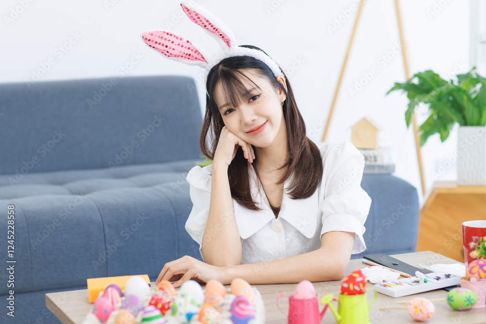 Asian beautiful attractive cheerful young cute lovely sweet woman wearing casual clothes bunny rabbit ears, happy smile look at camera at home with painted colorful eggs decorated for Easter celebrate Asian beautiful attractive cheerful young cute lovely sweet woman wearing casual clothes bunny rabbit ears, happy smile look at camera at home with painted colorful eggs decorated for Easter celebrate