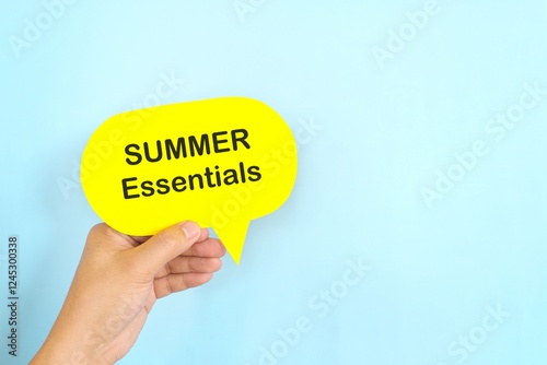 Obraz na płótnie Summer essentials and safety tips reminder concept. Hand holding bright yellow speech bubble in blue background. w salonie
