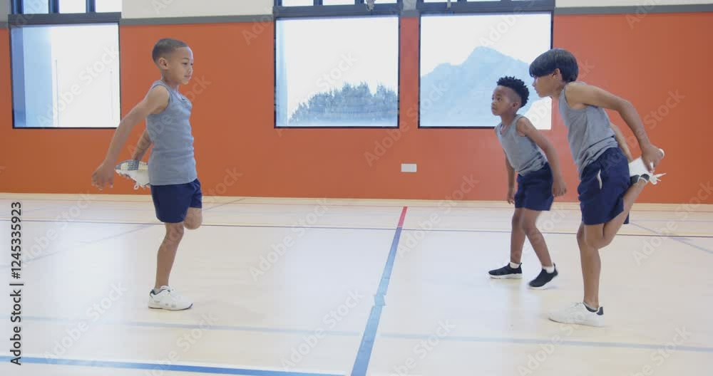 In school gym, three boys jumping rope and exercising together In school gym, three boys jumping rope and exercising together