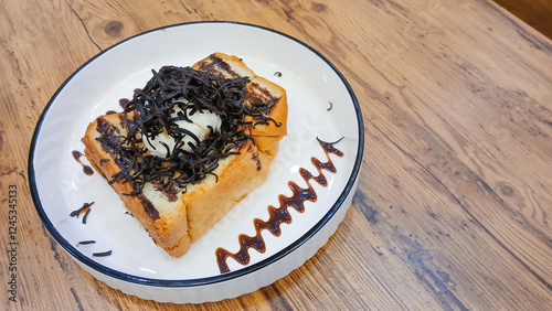 toast in a white plate with delicious chocolate sauce. Food concept with wooden table background.