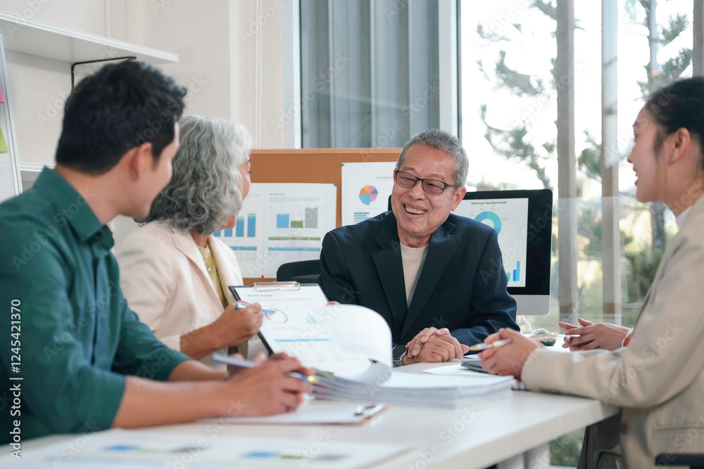 Asian businesspeople discussing financial reports during a meeting