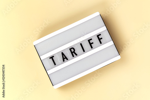 A lightbox displays the word TARIFF against a soft yellow background photo