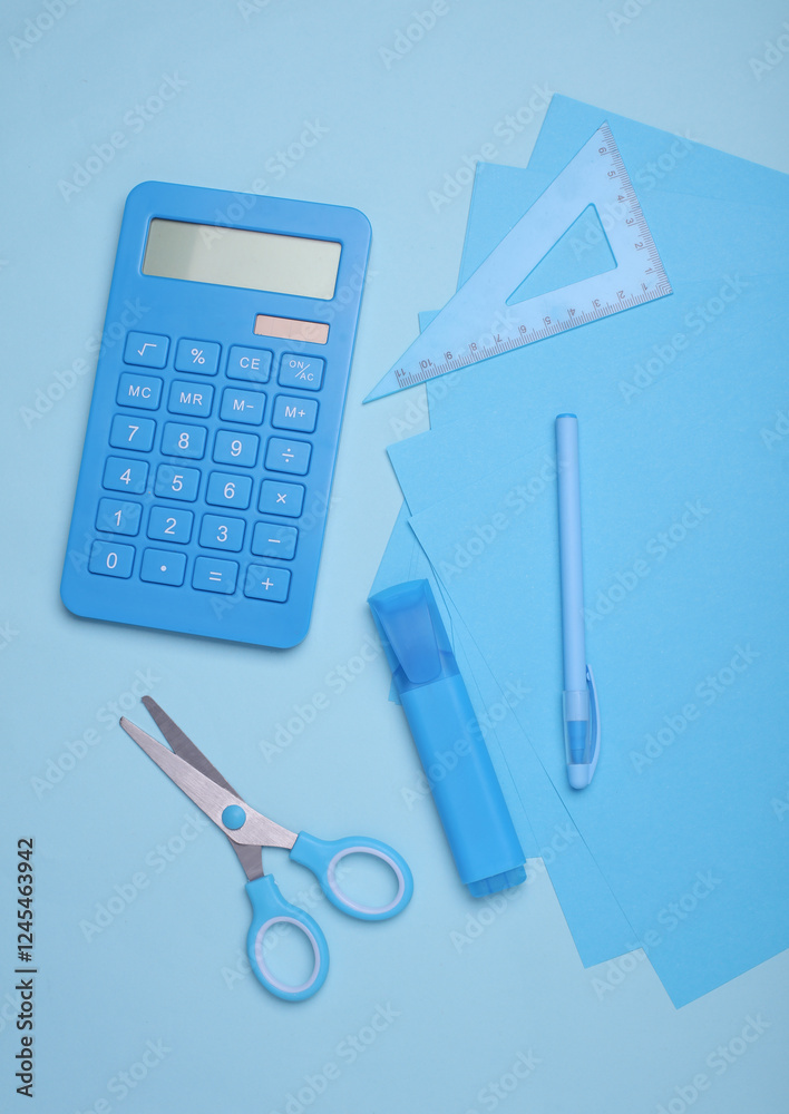 Blue sheets of paper with school stationery on blue background. Monochrome photography. Flat lay. Creative layout Blue sheets of paper with school stationery on blue background. Monochrome photography. Flat lay. Creative layout