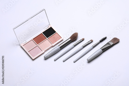 Makeup eyeshadow palette and brushes on white background