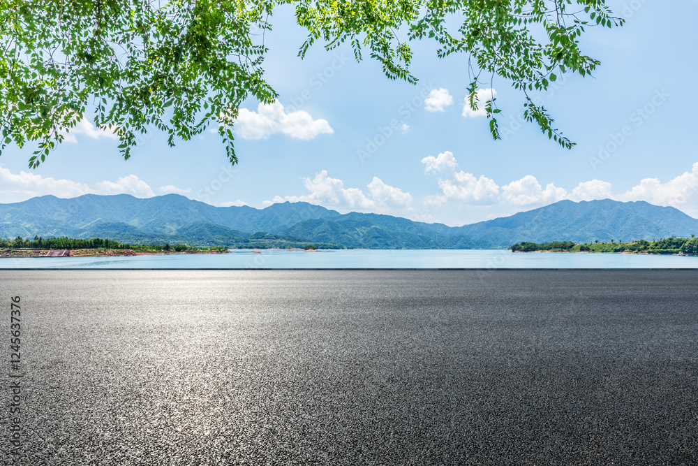 Asphalt road and blue lake with mountain nature landscape under blue sky
