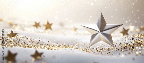 A polished silver star rests on a soft white surface surrounded by scattered golden stars and glimmering glitter creating a enchanting holiday scene