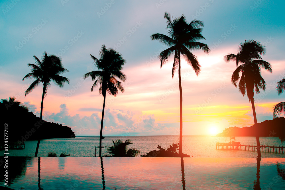 Obraz premium Pool with palm trees near the ocean during a beautiful sunset,copy space.