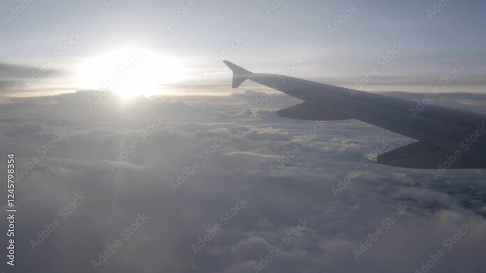 view through the window of the airplane from inside cabin while flyiing climbing into the sky above the cloudscape outside in sunset time,natural transportation holiday vacation background