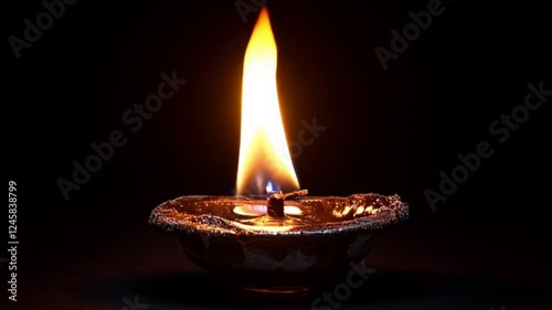Single oil lamp flame glowing dark background, hope, peace, spirituality