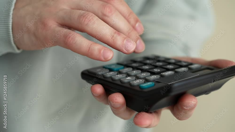 Close-up of hands using a calculator for financial calculations Close-up of hands using a calculator for financial calculations